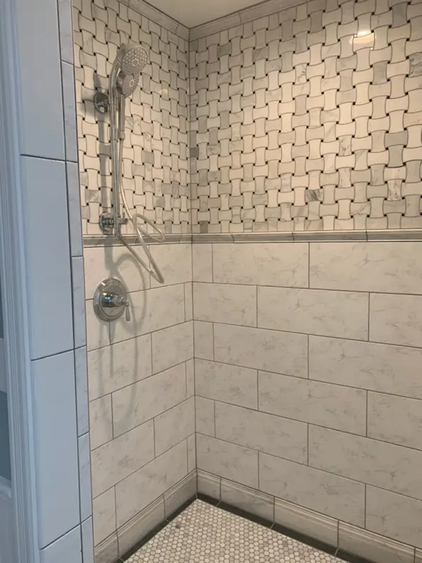 Finished shower with basketweave mosaic upper walls and marble subway below