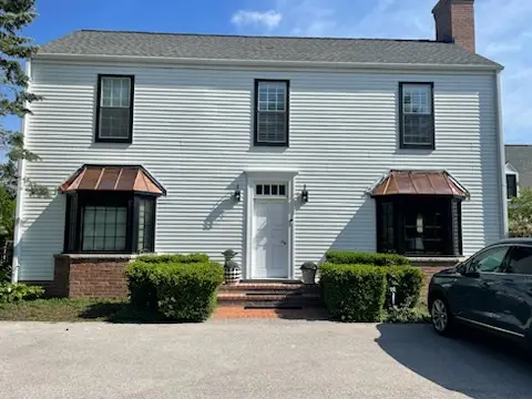 Finished house front with two copper-roofed bay windows