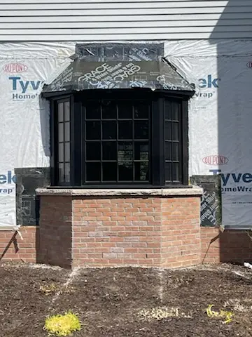 Bay window on its new brick base, house in Tyvek