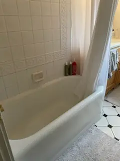 Before: white tub with tile surround