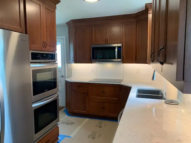 Cherry cabinets with quartz counters and white subway backsplash