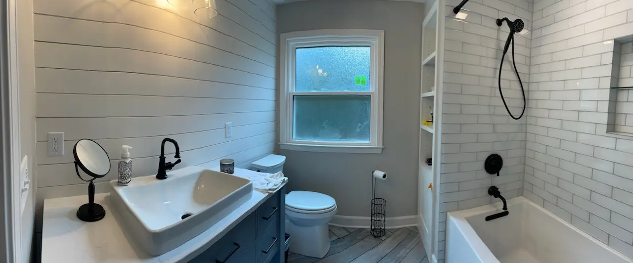 Full view of the farmhouse bath: shiplap wall, vessel sink, subway tub surround