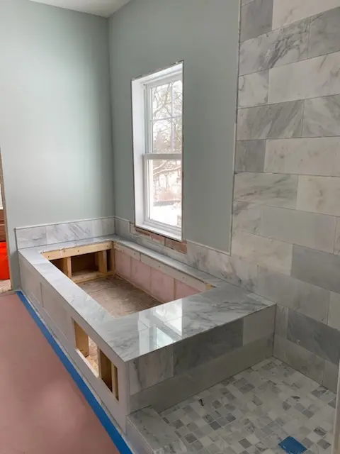 Tiled tub deck under a window during construction
