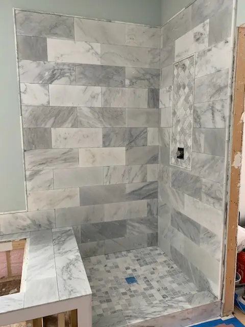 Marble subway shower with mosaic accent band, in progress
