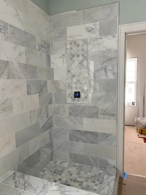 Walk-in shower tiled floor to ceiling, before glass