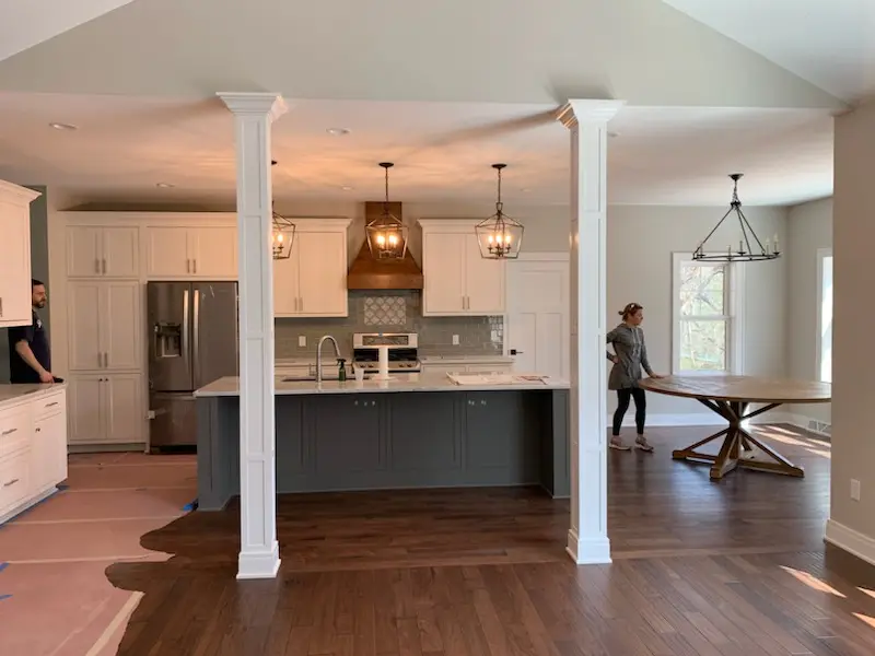 Kitchen and dining area with paneled columns, floors being finished