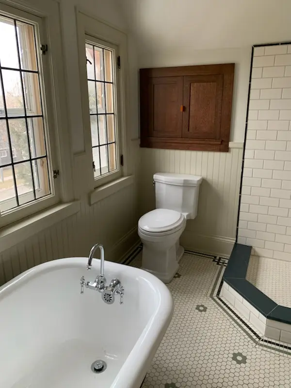 Clawfoot tub, oak medicine cabinet, and subway-tiled shower