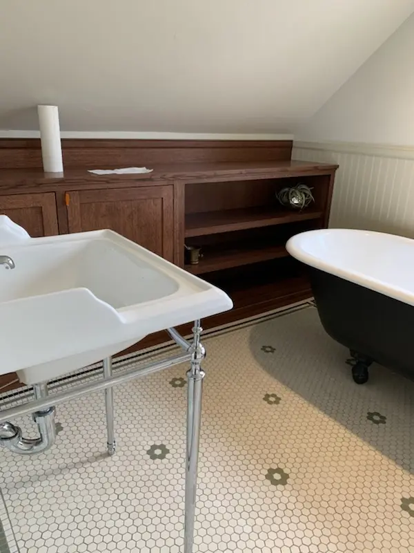 Built-in quarter-sawn oak cabinets beside the clawfoot tub
