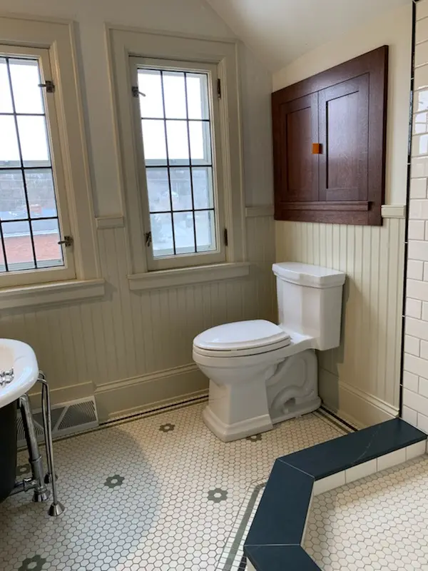 Toilet below a custom oak medicine cabinet