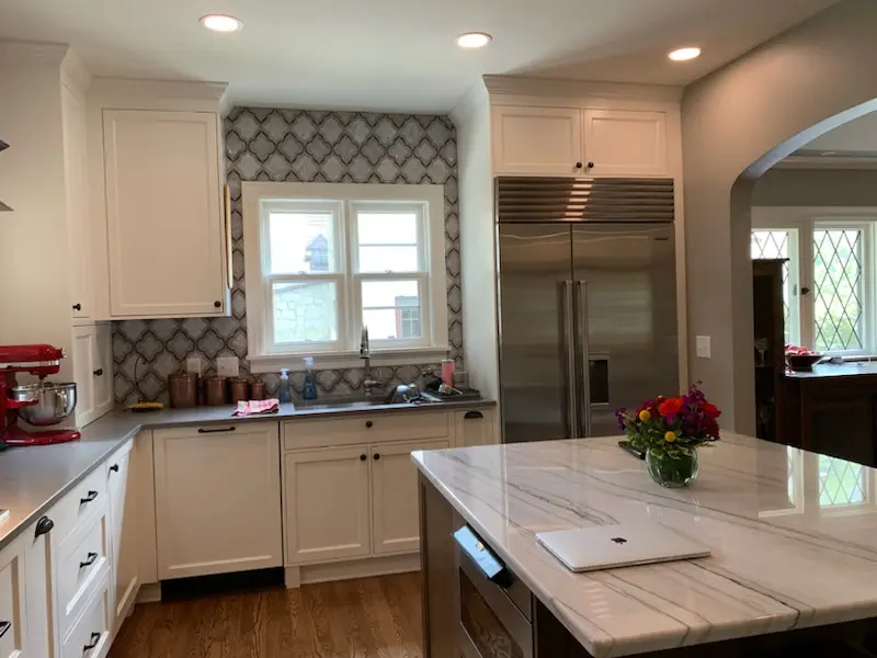 Arabesque marble backsplash, custom hood, and quartzite island