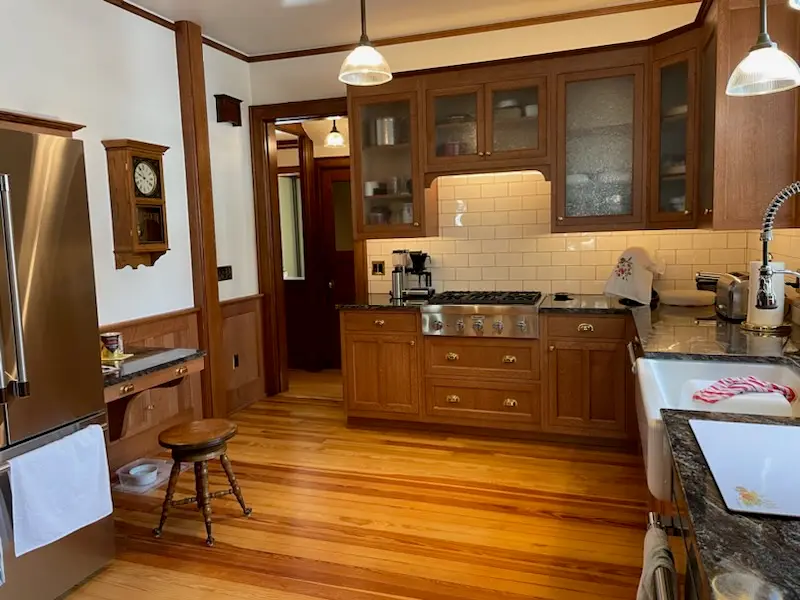 Range wall with brass hardware, granite counters, and oak trim