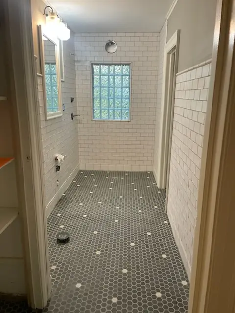 Finished walk-in shower with subway walls and gray penny floor