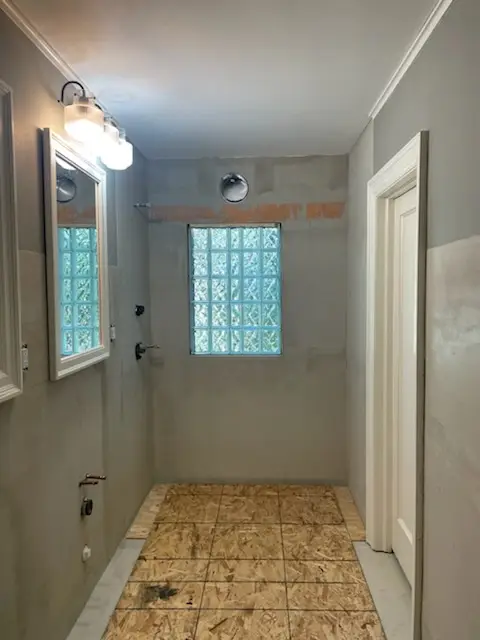 Gutted room with new glass-block window and cement board