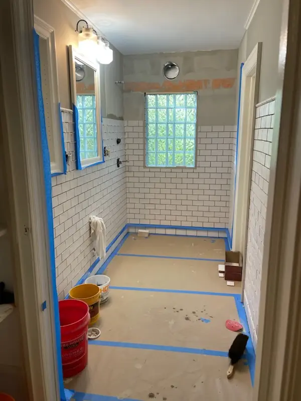 Subway tile going up around the glass-block window